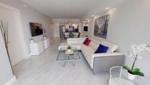 un soggiorno con divano bianco e tavolo di Ocean Reserve Condo by FlatsAway a Miami Beach