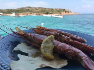 a plate of food with lobsters and a slice of lime at Casa Ilva in La Maddalena