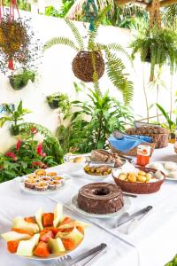 a table topped with plates of fruit and cakes at Coroaci Beach House in Barra Grande