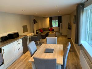 a kitchen and living room with a table and chairs at Fornham Guest House in Chertsey