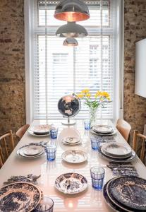 a dining room table with plates and glasses on it at Csar Private Guesthouse in Bruges