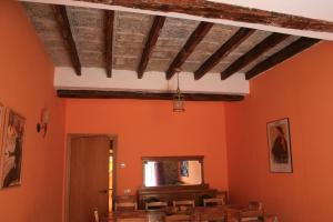 comedor con paredes de color naranja y techo de madera en La Polaina, en Montblanc