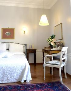 a bedroom with a bed, chair, table and lamp at Hotel Lancelot in Rome