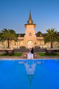 a building with a table in front of a pool at Swakopmund Hotel & Entertainment Centre in Swakopmund