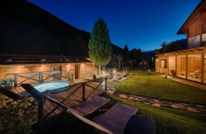 a backyard with a hot tub and a house at Apartments & Wellness Löfflerblick in Cadipietra