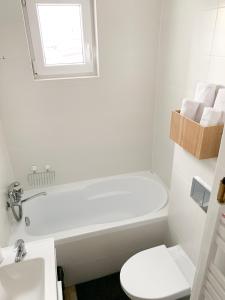 a bathroom with a tub and a toilet and a sink at Apartament Kotwica in Gdynia +14 photos