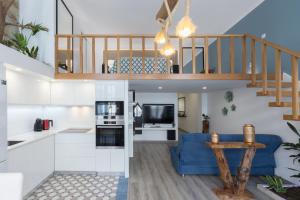 a kitchen and living room with a staircase and a blue couch at Deluxe Spacious Flats w Mezzanine by Host Wise in Porto