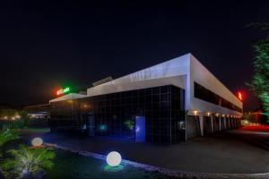 a building with a green sign on it at night at Motel Emoções in Nogueira da Regedoura