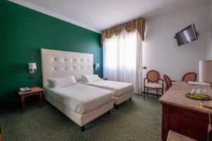 um quarto de hotel com uma cama e uma parede verde em Hotel La Torretta em Bollate