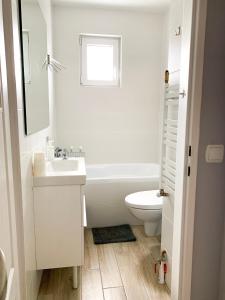 グディニャにあるApartament Kotwicaの白いバスルーム(洗面台、トイレ付)