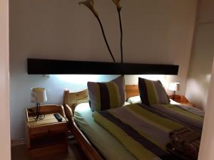 a bedroom with two beds and a night stand with two lamps at Apartmenthotel Hohegeiß Kasing MIT FREIEM WLAN und Schwimmbad in Hohegeiß