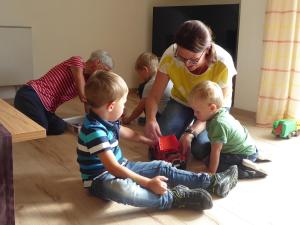 a group of children sitting on the floor playing with a toy truck at Apollonias Gästehaus in Bibertal 