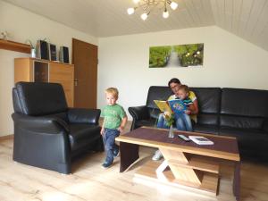 a woman and a child sitting on a couch with a table at Apollonias Gästehaus in Bibertal 