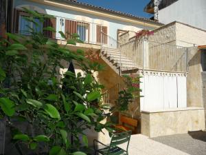 a green chair sitting next to a building with stairs at Galatea in Mascali