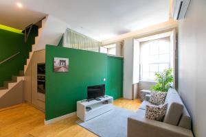 a living room with a green wall at Casa da Cordoaria in Porto