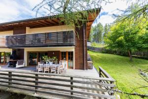 a house with a wooden deck with a table at Chalet Avidea Secret in Avelengo