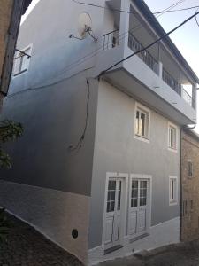 Casa dos Avós e Netos في فانداو: مبنى ابيض بباب وبلكونه