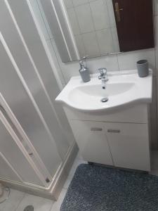La salle de bains est pourvue d'un lavabo blanc et d'un miroir. dans l'établissement Casa dos Avós e Netos, à Fundão