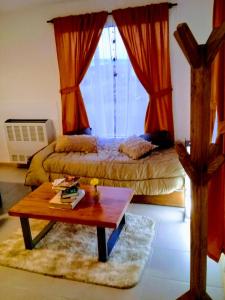 Schlafzimmer mit einem Bett, einem Tisch und einem Fenster in der Unterkunft Javis House in El Calafate