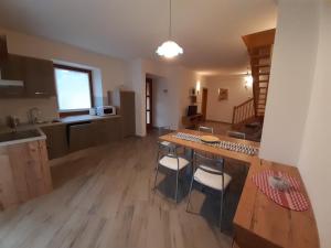 a kitchen with a table and chairs in a room at Appartamento Morettina con terrazzo in Levico Terme