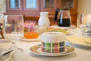 einen Tisch mit einer Tasse, Tellern und Weingläsern in der Unterkunft Casa do Outeiro in Sobradelo da Goma