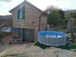 a pool in front of a stone house at Eidos da laxe in Sela