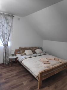 a bedroom with a large bed and a window at Tesla Coil Apartments in Gospić