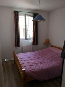 ein Schlafzimmer mit einem lila Bett und einem Fenster in der Unterkunft appart luz in Luz-Saint-Sauveur