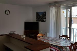 a living room with a dining table and a television at appart luz in Luz-Saint-Sauveur
