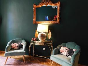 a living room with two chairs and a mirror at Wonder Deer Lux Apartment at the Parliament self check-in in Budapest