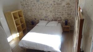 a bedroom with a bed with white sheets and pillows at Appartement avec patio,2 chambres,Patangarles in Arles