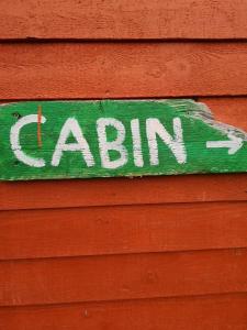 una señal en el lateral de un edificio rojo en East Coast Newfoundland Cottage & Cabins en Bauline East