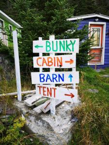 un letrero de la calle con flechas apuntando en diferentes direcciones en East Coast Newfoundland Cottage & Cabins en Bauline East