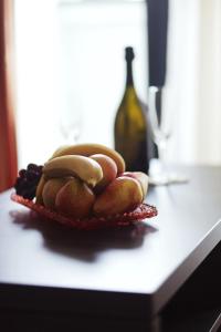 a plate of fruit on a counter with a bottle of wine at Hotel Kardial in Teslić