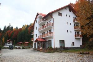 ein großes weißes Gebäude mit vielen Balkonen in der Unterkunft Hotel Paltinis in Statjunea Borsa
