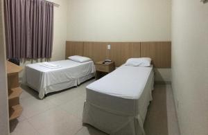 a hospital room with two beds and a window at Hotel Rotamerica in Campinorte