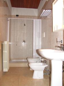 a bathroom with two toilets and a sink and a shower at Hotel Genius in Corato