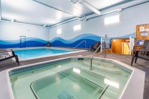 a large swimming pool in a building with a swimming pool at Ramada by Wyndham Coquitlam in Coquitlam