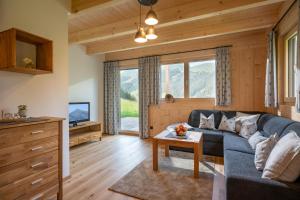 ein Wohnzimmer mit einem Sofa und einem Tisch in der Unterkunft Chalet Alpenherz in Kirchberg in Tirol