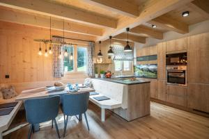a kitchen with wooden walls and a table and chairs at Chalet Alpenherz in Kirchberg in Tirol