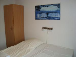 a bedroom with a bed and a painting on the wall at Polar Lodge in Kangerlussuaq