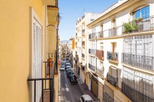 einen Balkon mit Blick auf eine Stadtstraße in der Unterkunft Shiny Lud Family Apartment in Málaga