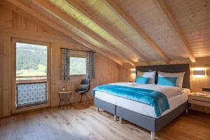 a bedroom with a bed and a large window at Chalet Alpenherz in Kirchberg in Tirol +45 photos