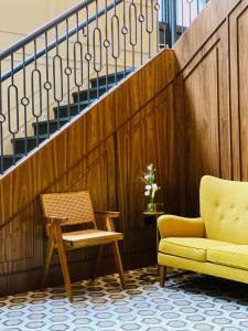 two chairs and a chair next to a staircase at Walker Hotel Tribeca in New York