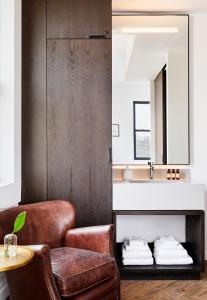 a living room with a chair and a sink at Walker Hotel Tribeca in New York