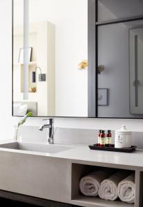 a bathroom with a sink and a mirror and towels at Walker Hotel Tribeca in New York