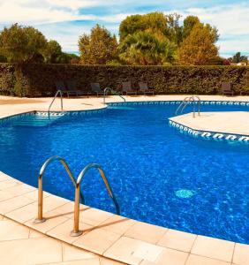 une piscine à l'eau bleue dans un complexe hôtelier dans l'établissement les reflets, à Saint Cyprien Plage
