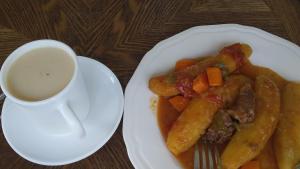 une assiette de nourriture avec des carottes et une tasse de café dans l'établissement Hotel Shine Sunet, à Mbarara