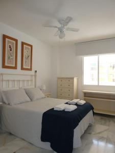 a bedroom with a bed with two towels on it at MALDONADO LUJO SUPERIOr CENTRO MALAGA in Málaga