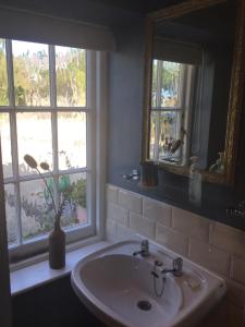a bathroom with a sink and a mirror and a window at Little Treasure with up to 25 percent off ferry in Shanklin